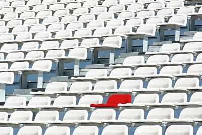 Red stadium seat in a mass of white seats